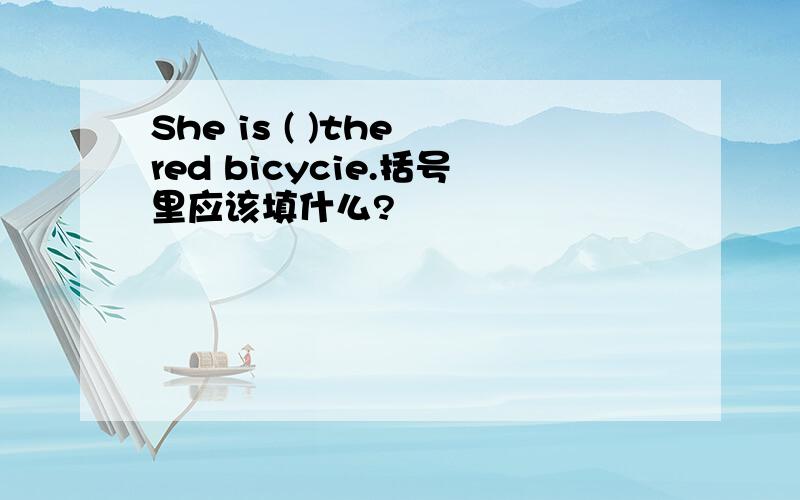 She is ( )the red bicycie.括号里应该填什么?