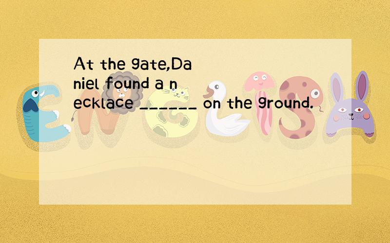 At the gate,Daniel found a necklace ______ on the ground.