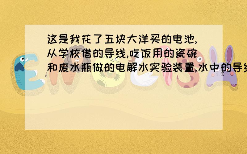 这是我花了五块大洋买的电池,从学校借的导线,吃饭用的瓷碗和废水瓶做的电解水实验装置,水中的导线头已经最大可能的靠近（不接